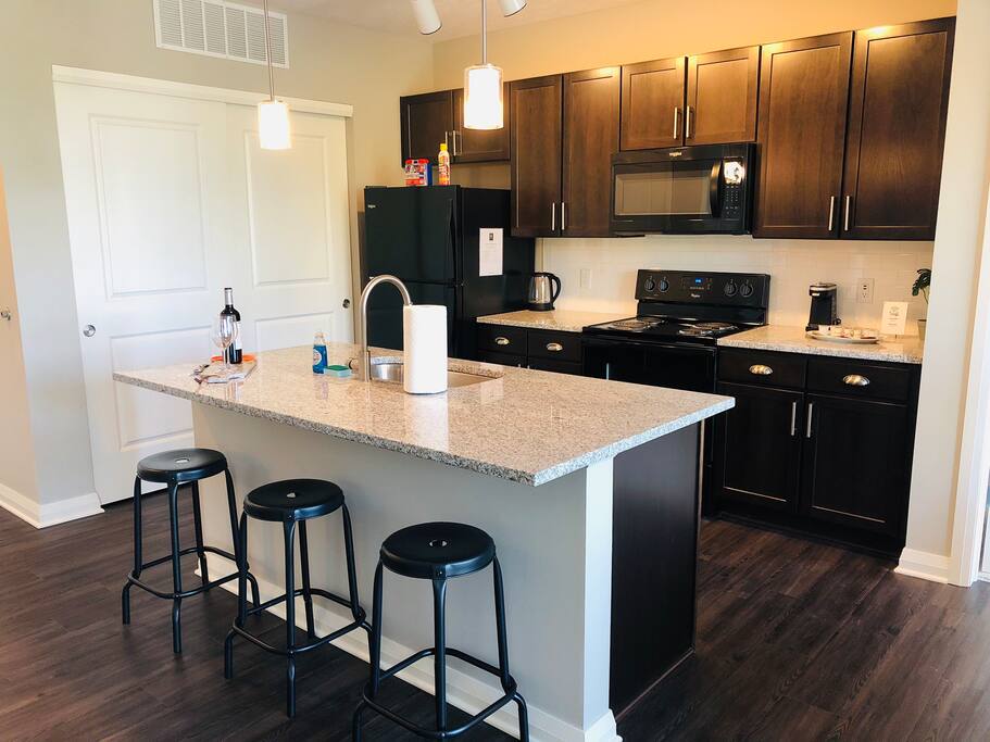 A fully stocked kitchen in a furnished apartment in Downtown Columbus with counter stools