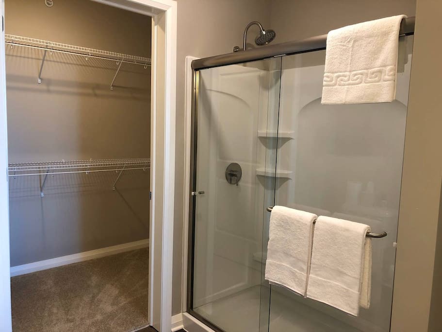 A walk-in shower and an attached walk-in closet in a furnished apartment in downtown Columbus