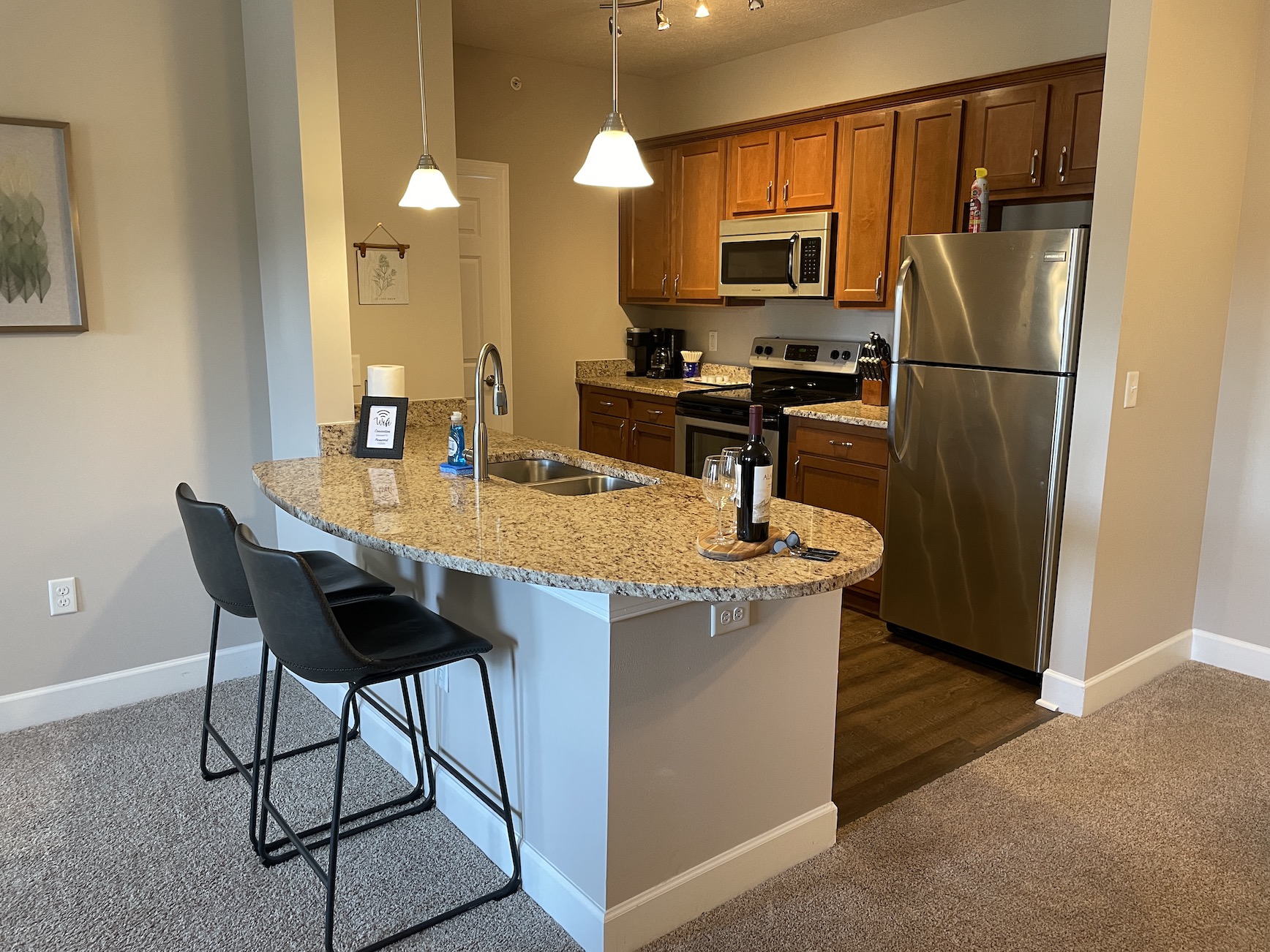 A fully stocked kitchen in a furnished apartment in Westerville Ohio with counter stools and decor